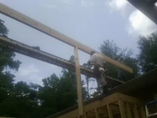 Carpenter setting a ridge beam over a new addition frame — Ice Dam Removal by Roofing Brothers in Ellicott City