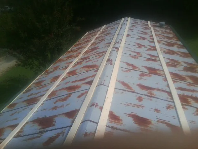 Rusted metal roof panels with new wood purlins before replacement — Storm Damage Roof Repair in Ellicott City by Roofing Brothers