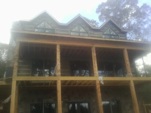 Dormers and porch framing on a large log home under construction — Roof Coating work by our crew in Ellicott City