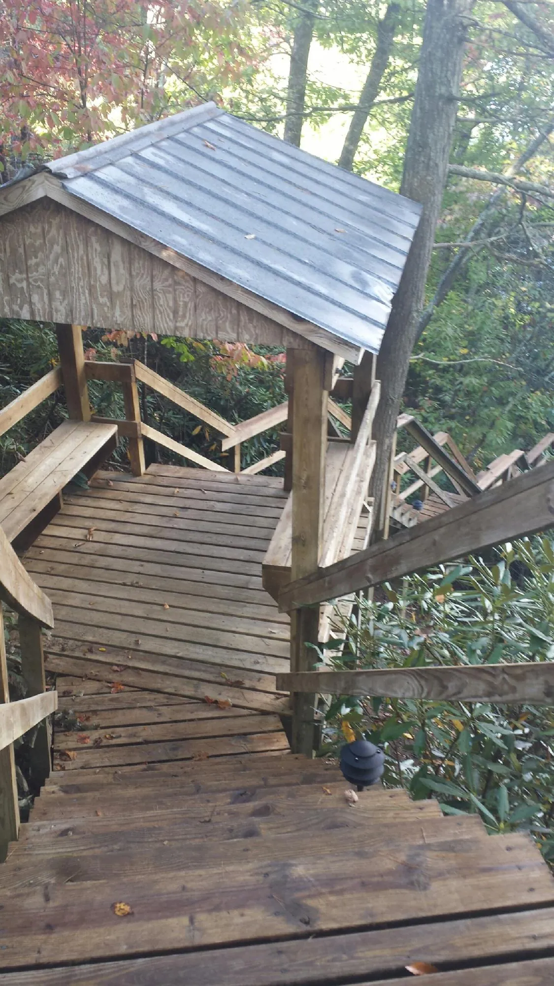 Metal roofed shelter over wooden steps on a wooded walkway — Skylight Repair & Installation work by our crew in Ellicott City