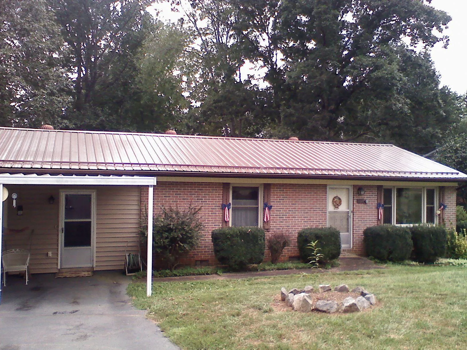 Bronze metal roof and carport on a brick ranch home — Roof Repair work by our crew in Ellicott City