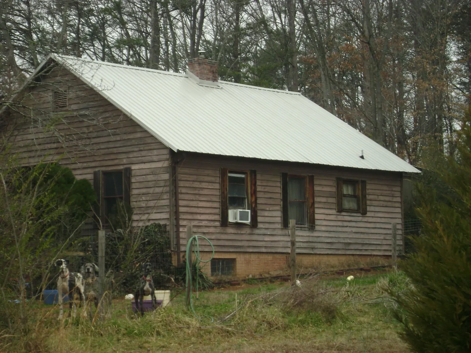 White metal roof on an old wood sided farmhouse, from a Metal Roof Installation job in Ellicott City