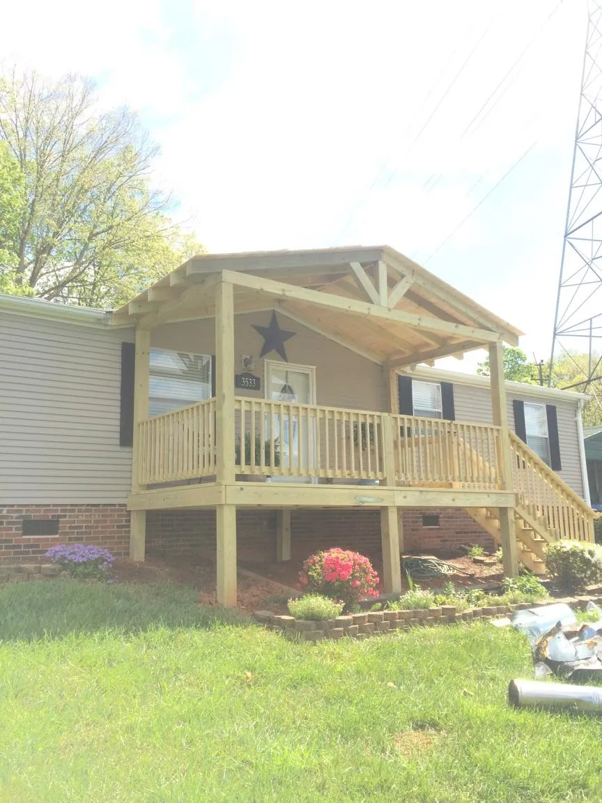 New gabled porch roof and deck railing added to a ranch home in Ellicott City